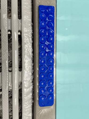 Suction strips securing swim touchpad to pool wall